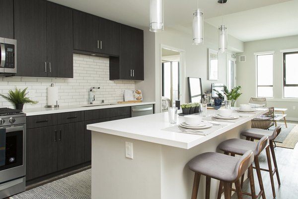 Modern kitchen with sleek cabinetry and marble countertops in Pierside South luxury apartments