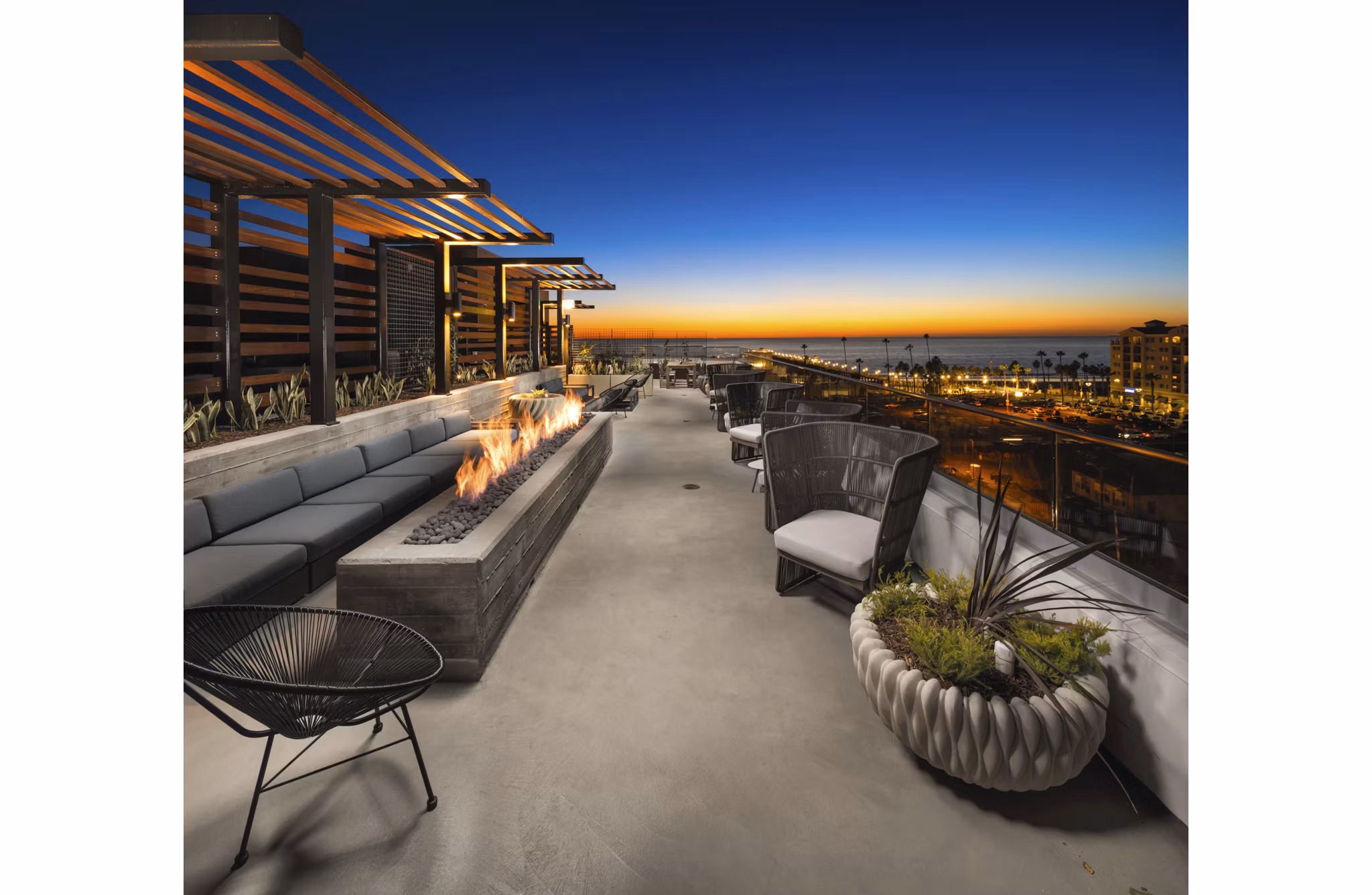 Pierside South Apartments: Stylish patio area with seating and greenery, offering a relaxing outdoor space for residents in coastal community