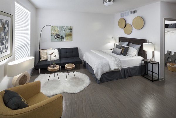Cozy bedroom featuring a plush queen bed and modern decor at Alexan West Highland apartments