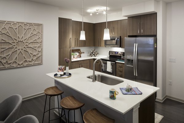 Modern kitchen with stainless steel appliances at Alexan West Highland luxury apartments