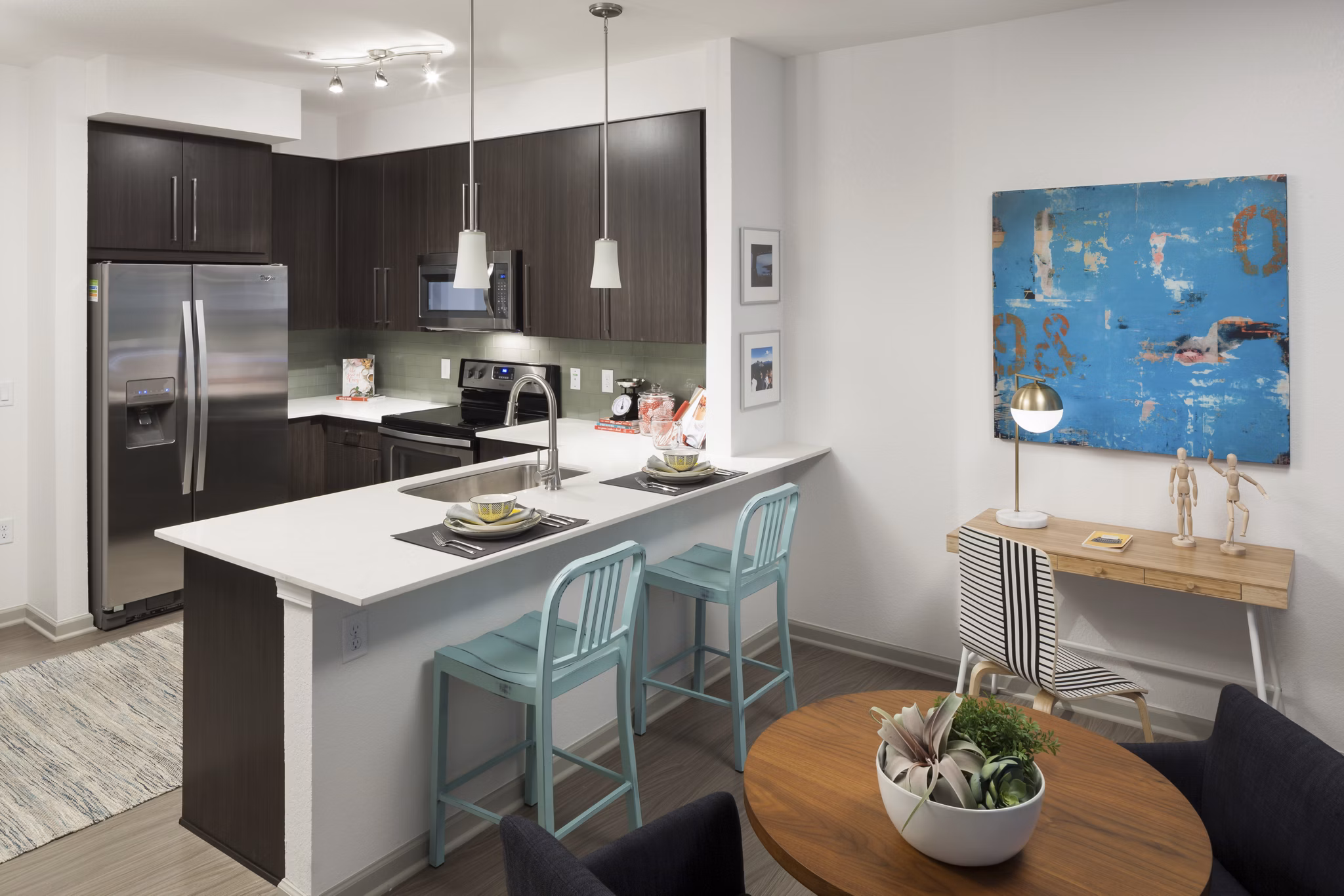 Modern kitchen with stainless steel appliances and granite countertops at Alexan West Highland luxury apartments