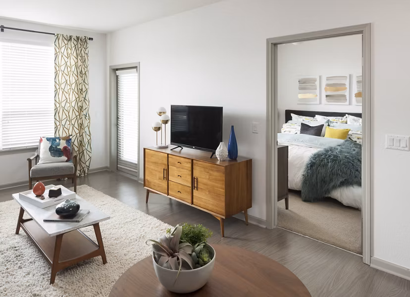 Modern living room with stylish furnishings and large windows at Alexan West Highland luxury apartments
