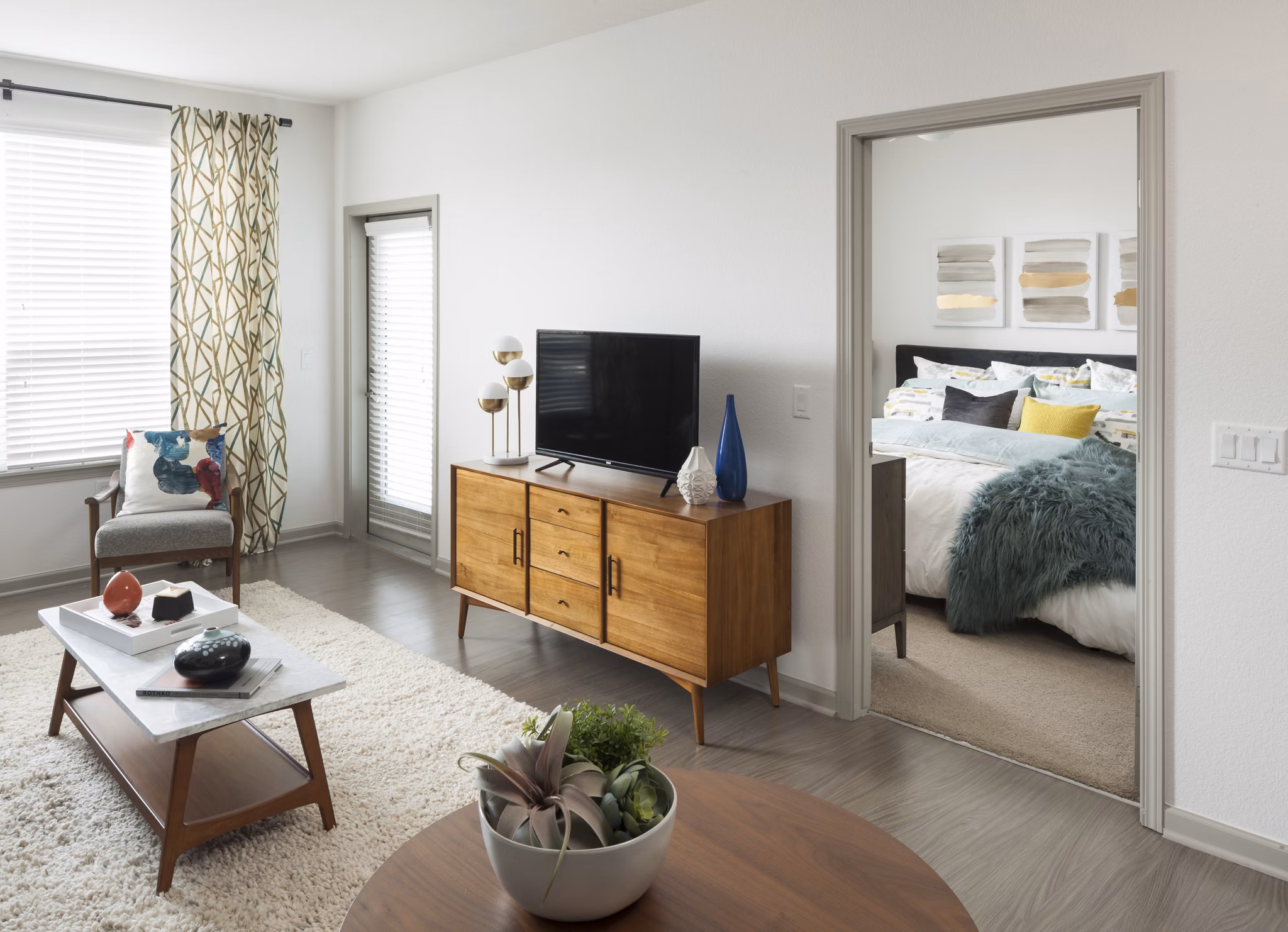 Modern living room with stylish furnishings and large windows at Alexan West Highland luxury apartments