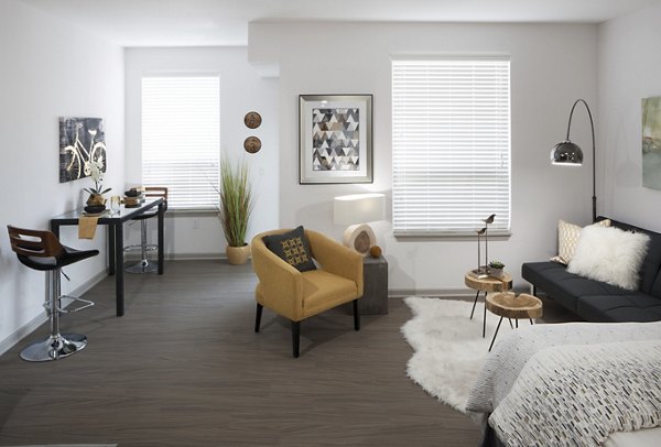 Living room with modern decor and large windows at Alexan West Highland luxury apartments