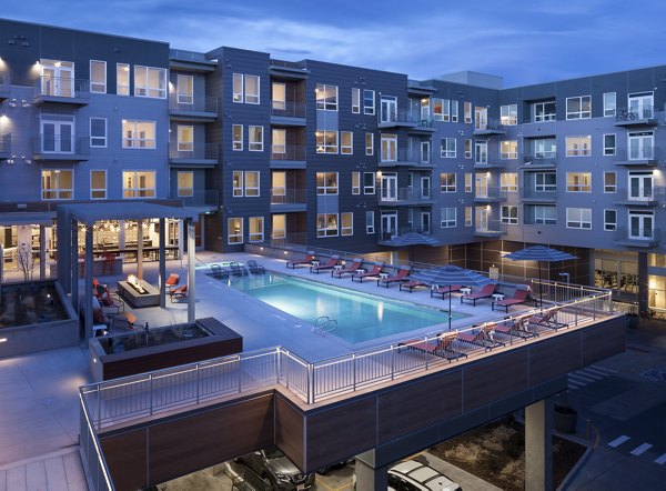 Resort-style pool at Alexan West Highland with sun loungers and scenic views