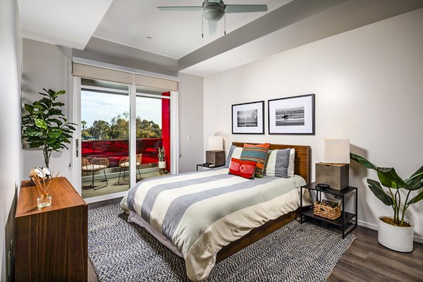 Elegant bedroom with large windows and modern decor in Burano Place Apartments