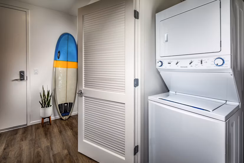 Laundry room equipped with modern washers and dryers at Burano Apartments, a Greystar luxury property