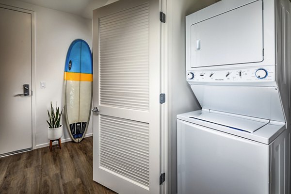 Laundry room equipped with modern washers and dryers at Burano Apartments, a Greystar luxury property
