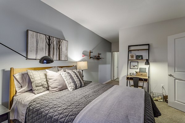 Cozy bedroom with modern decor at Venue on 16th Apartments, featuring plush bedding and ample natural light