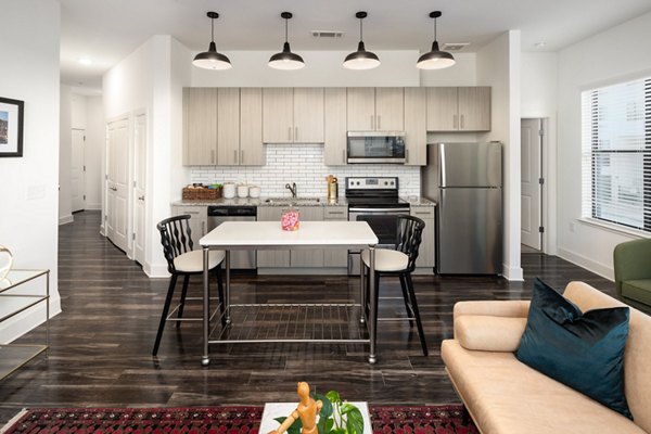 Dining area featuring elegant furnishings and large windows at The Oliver Apartments