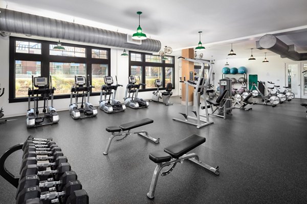 Fitness center with modern equipment at The Oliver Apartments, featuring expansive workout space and facilities for a healthy lifestyle