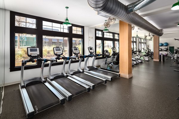 Fully equipped fitness center at The Oliver Apartments, featuring state-of-the-art workout machines and group classes