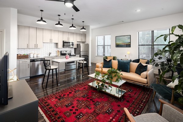 Living room featuring modern decor and large windows in The Oliver Apartments, luxury units by Greystar