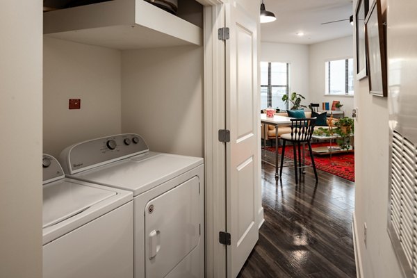 Laundry room with modern appliances at The Oliver Apartments