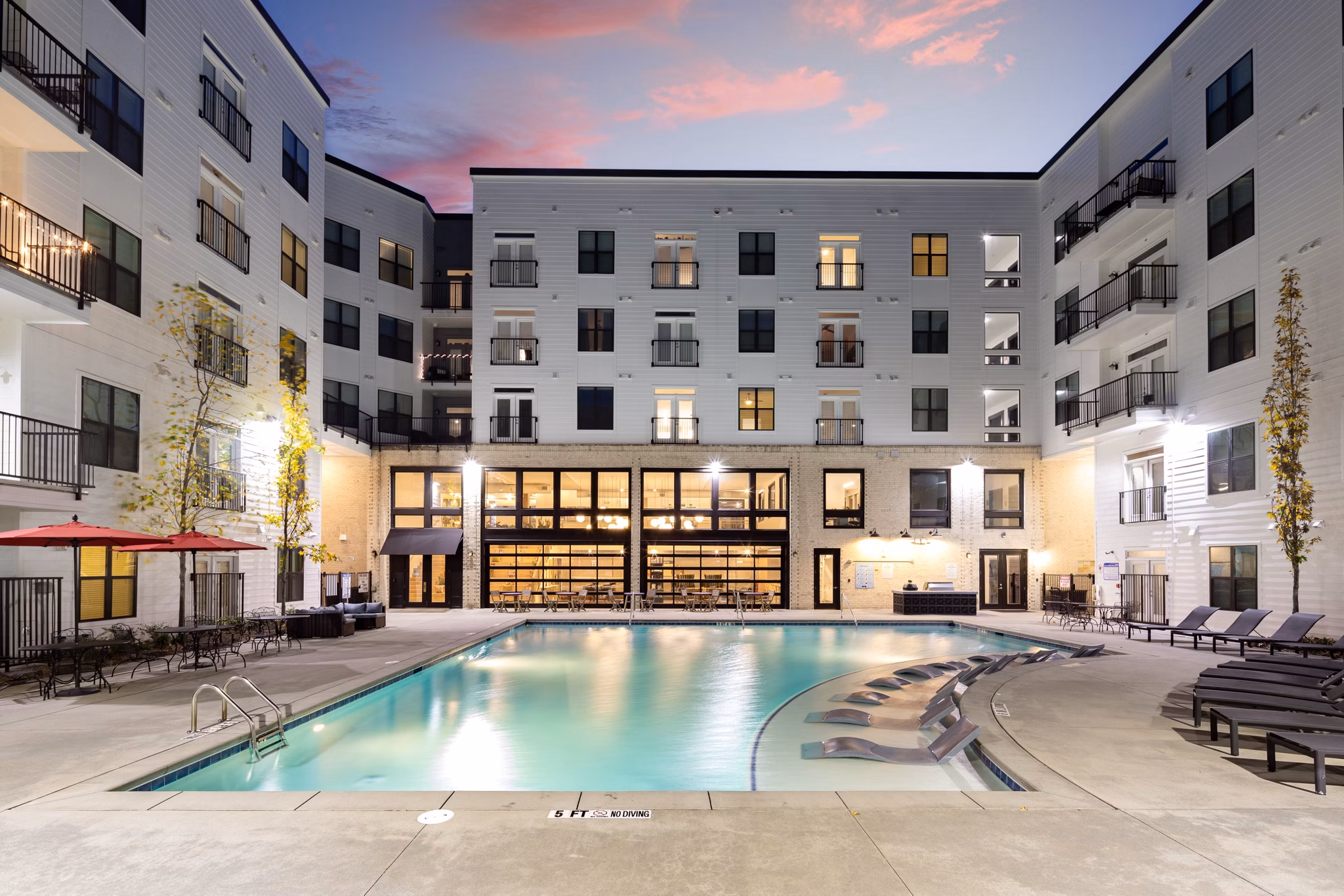 Resort-style pool with sun loungers at The Oliver Apartments, offering luxury living for Greystar residents
