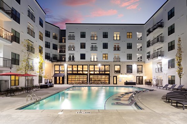 Resort-style pool with sun loungers at The Oliver Apartments, offering luxury living for Greystar residents