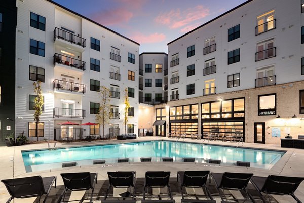 The Oliver Apartments: Luxury pool with seating area and lush landscaping