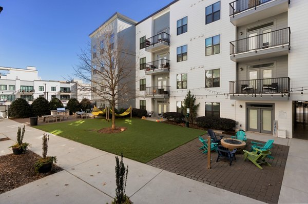 Serene courtyard with lush greenery and modern seating at The Oliver Apartments luxury complex