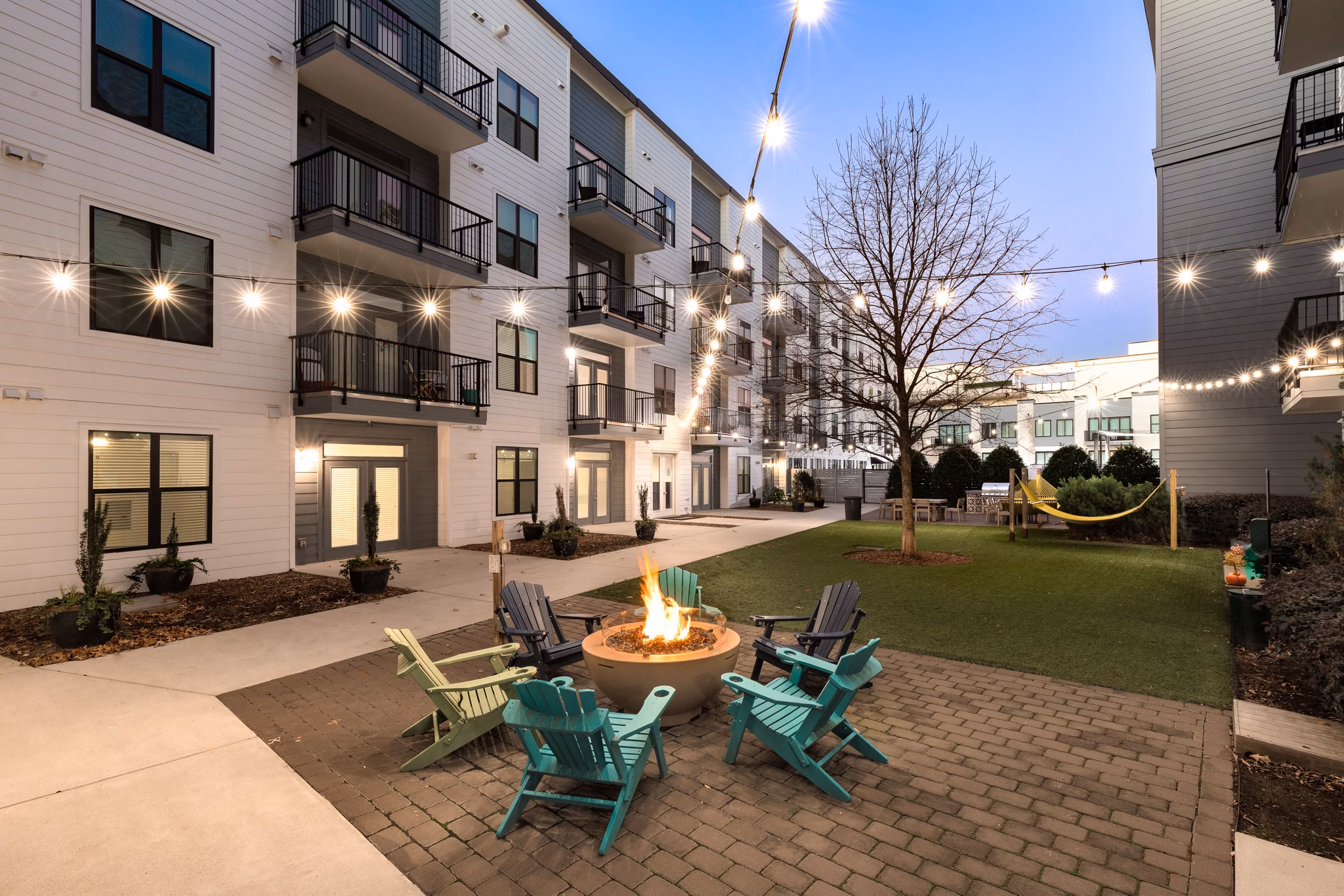 Cozy outdoor fire pit area at The Oliver Apartments, ideal for social gatherings and relaxation in stylish outdoor setting