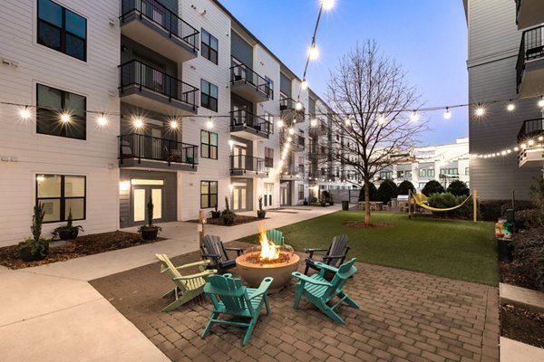 Cozy outdoor fire pit area at The Oliver Apartments, ideal for social gatherings and relaxation in stylish outdoor setting