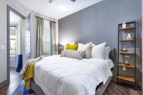 Bedroom with modern furnishings and city views at Flatiron Domain Apartments