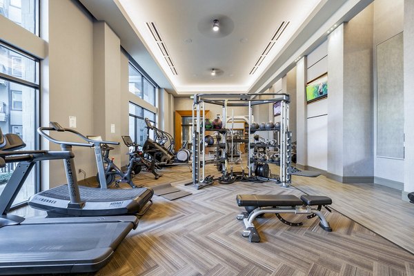 Modern fitness center with state-of-the-art equipment at Flatiron Domain Apartments, perfect for active lifestyles in a luxury setting