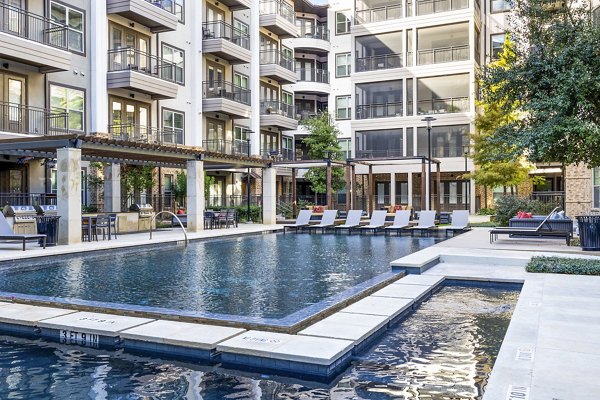 Relaxing poolside area with loungers and umbrellas at Flatiron Domain Apartments, a luxury community in Austin, Texas