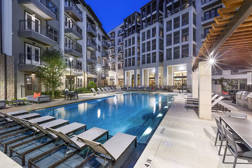 Relaxing pool area with modern loungers at Flatiron Domain Apartments, Austin