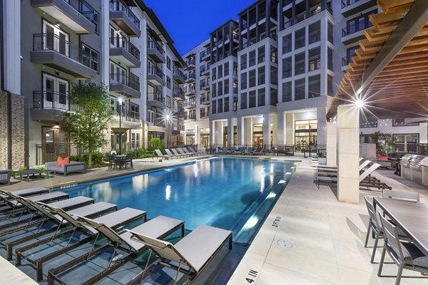 Relaxing pool area with modern loungers at Flatiron Domain Apartments, Austin