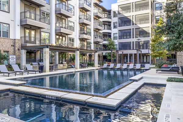 Pool at Flatiron Domain Apartments: Luxury pool area with modern seating and lush greenery at upscale Flatiron Domain community in Austin