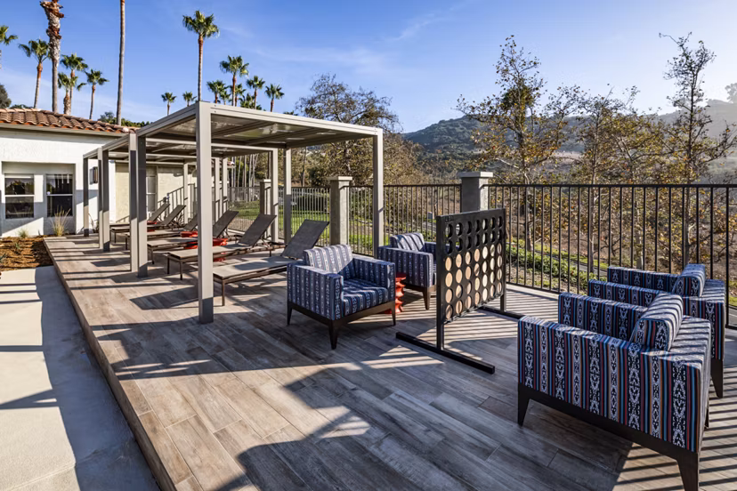 Outdoor entertainment area with lounges and games at Seacrest Apartment Homes