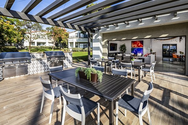 Grill area with modern seating and lush landscaping at Seacrest Apartment Homes