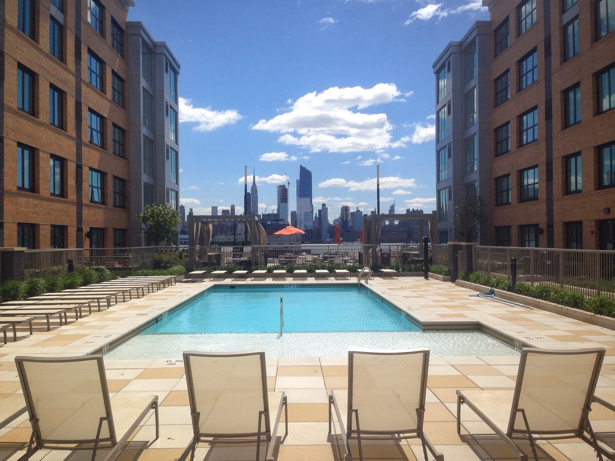 Relaxing outdoor pool at Estuary Apartments featuring luxury poolside seating