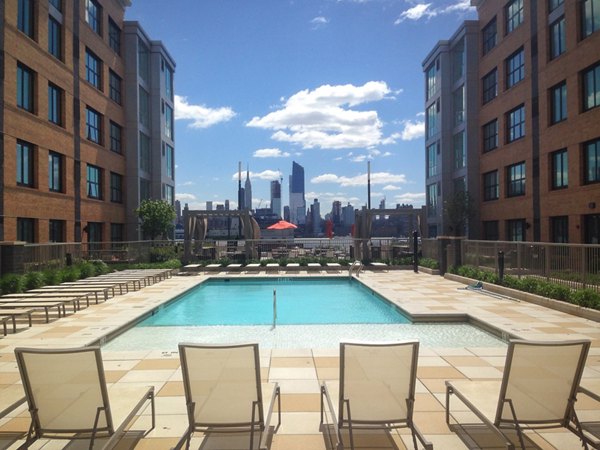 Relaxing outdoor pool at Estuary Apartments featuring luxury poolside seating