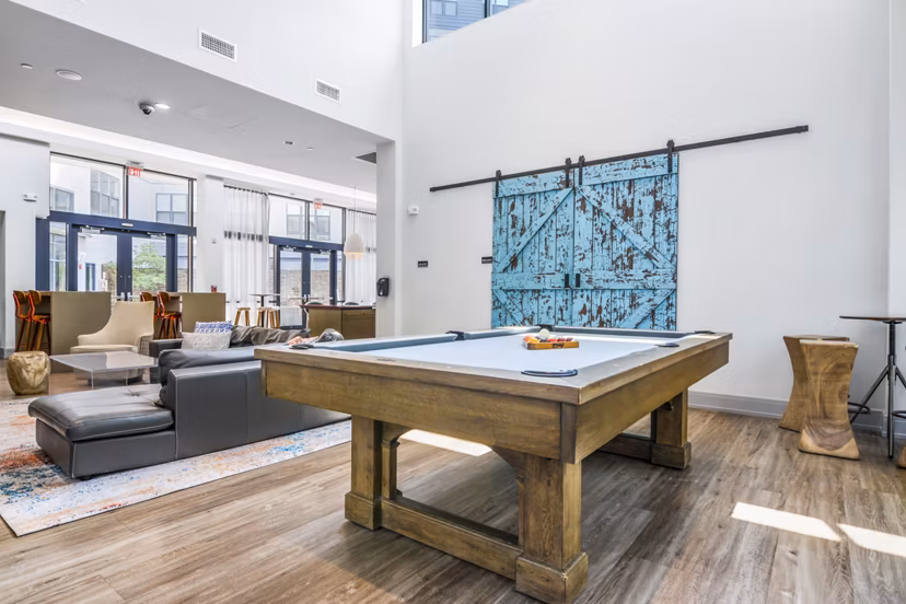 Clubhouse game room featuring pool table and modern decor at West of Chestnut Apartments