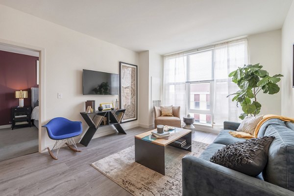 Modern living room with sleek furnishings and natural light at West of Chestnut Apartments