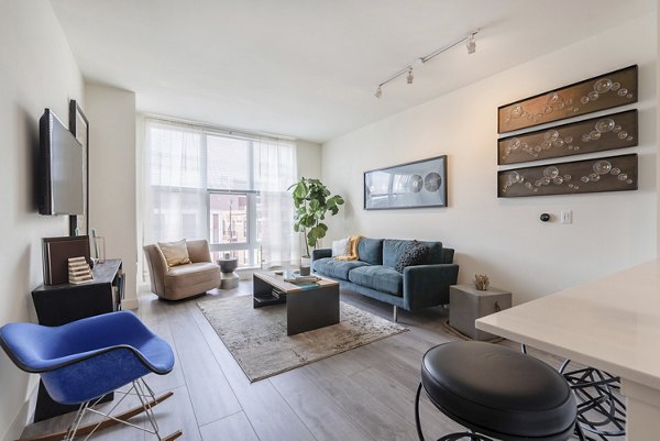 Spacious living room with modern decor at West of Chestnut Apartments