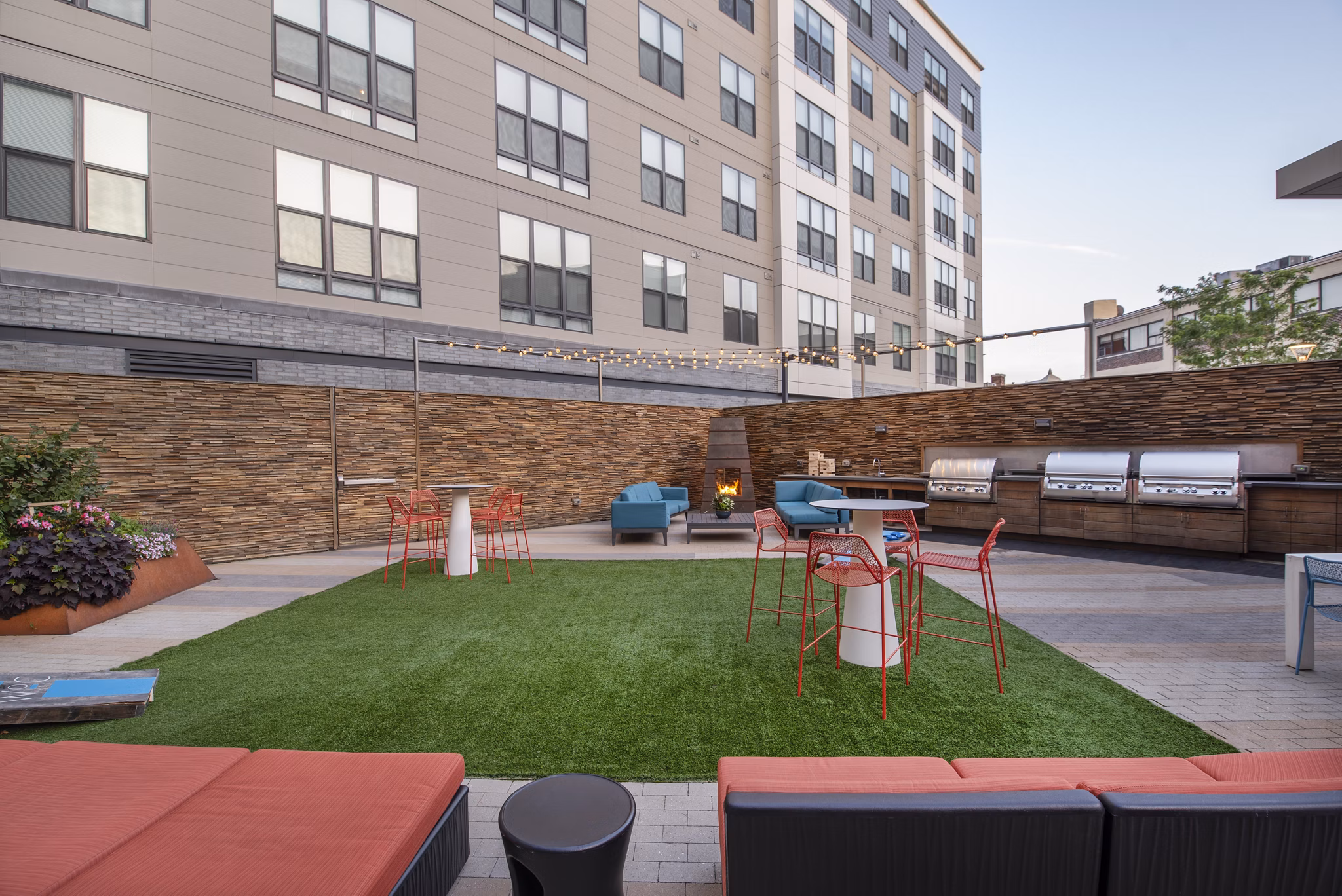 Outdoor grill area with modern seating at West of Chestnut Apartments, perfect for social gatherings in Quincy, MA