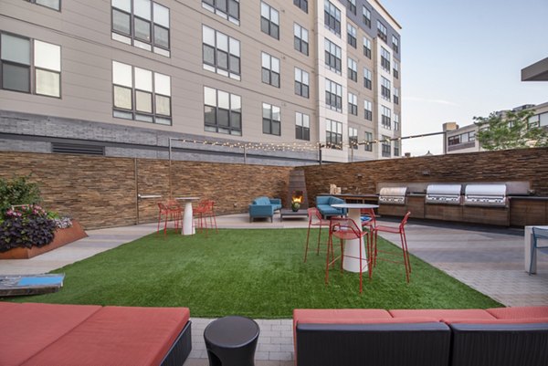 Outdoor grill area with modern seating at West of Chestnut Apartments, perfect for social gatherings in Quincy, MA
