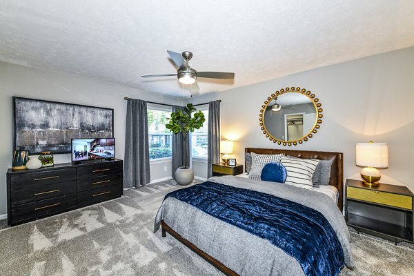 Avana Woods Apartments: Cozy bedroom with modern decor and large window for natural light