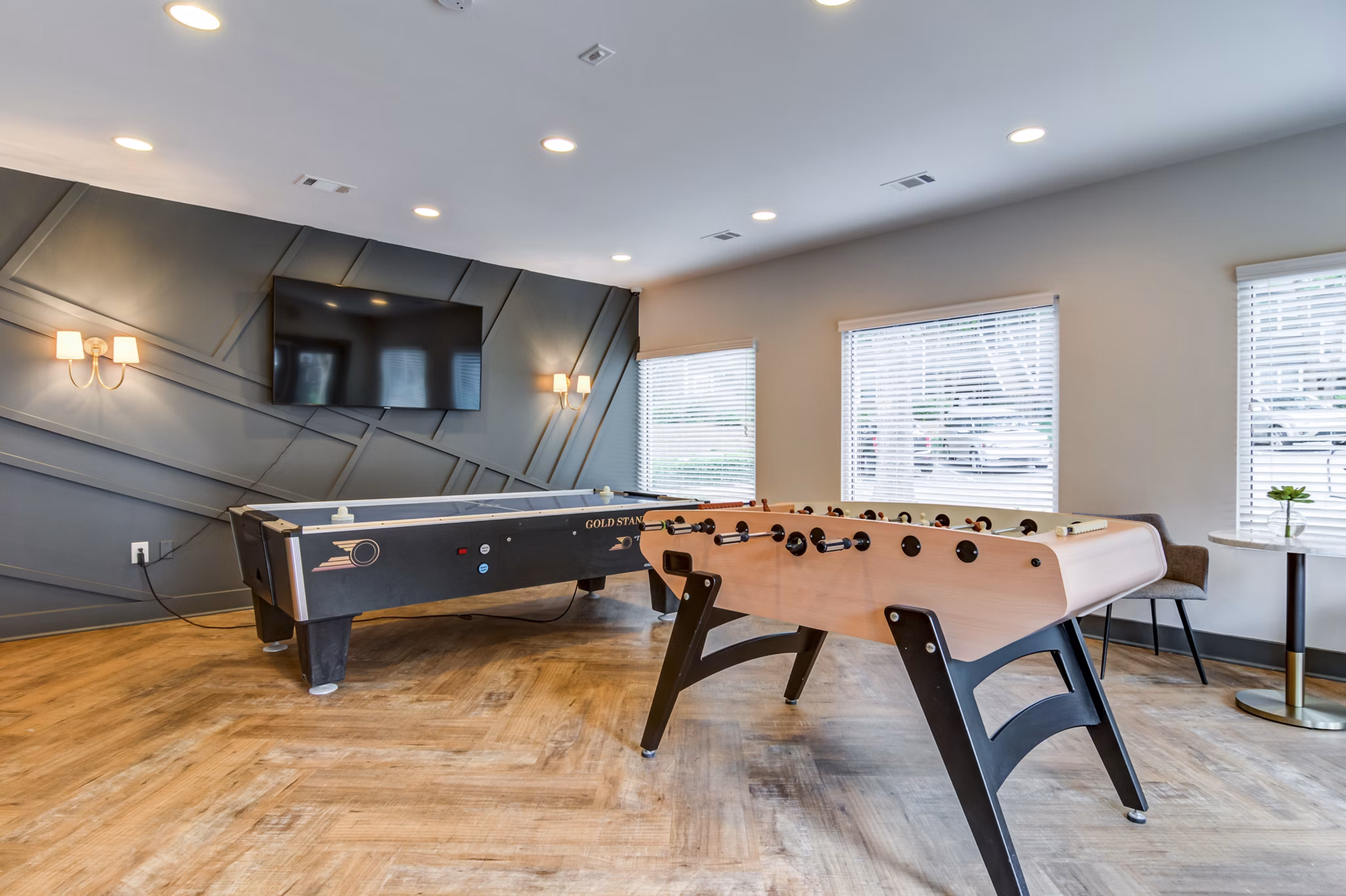 Modern game room with pool table and lounge seating at Avana Woods Apartments