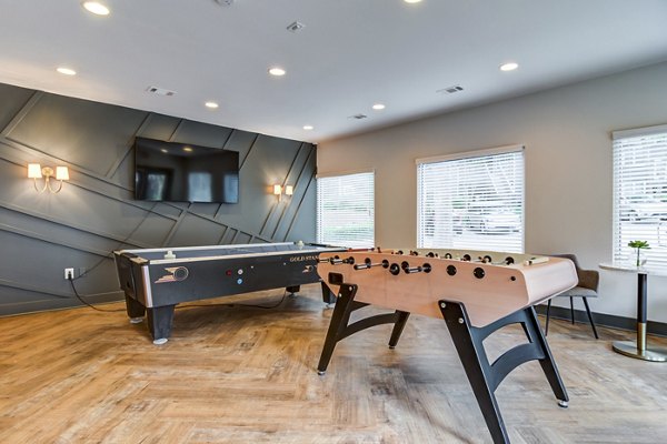 Modern game room with pool table and lounge seating at Avana Woods Apartments