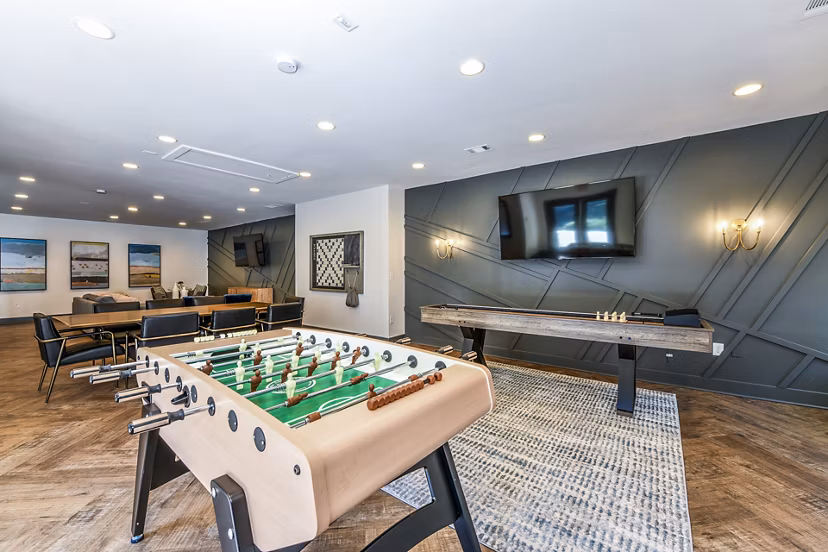 Game room with pool table and lounge seating in Avana Woods Apartments for relaxation and entertainment