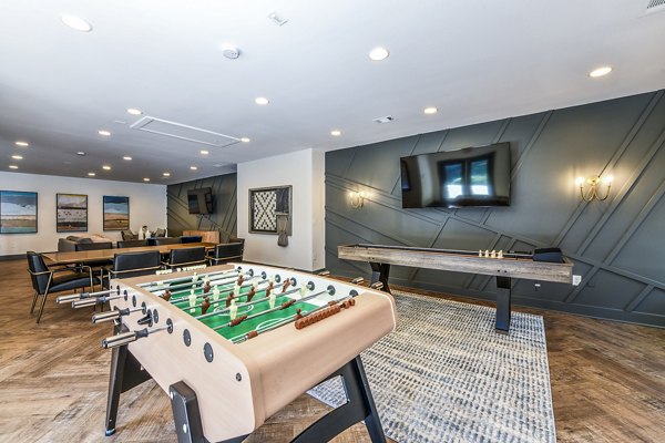 Game room with pool table and lounge seating in Avana Woods Apartments for relaxation and entertainment