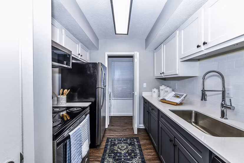 Modern kitchen with granite countertops and stainless steel appliances at Avana Woods Apartments