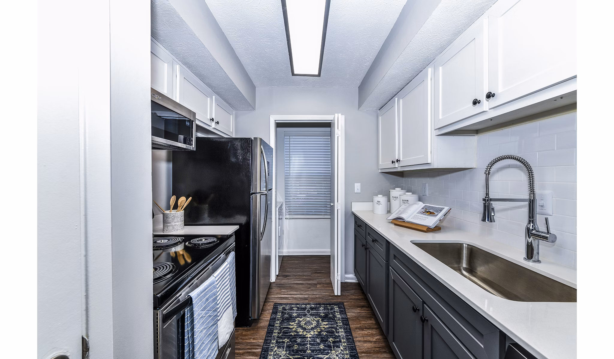 Modern kitchen with granite countertops and stainless steel appliances at Avana Woods Apartments