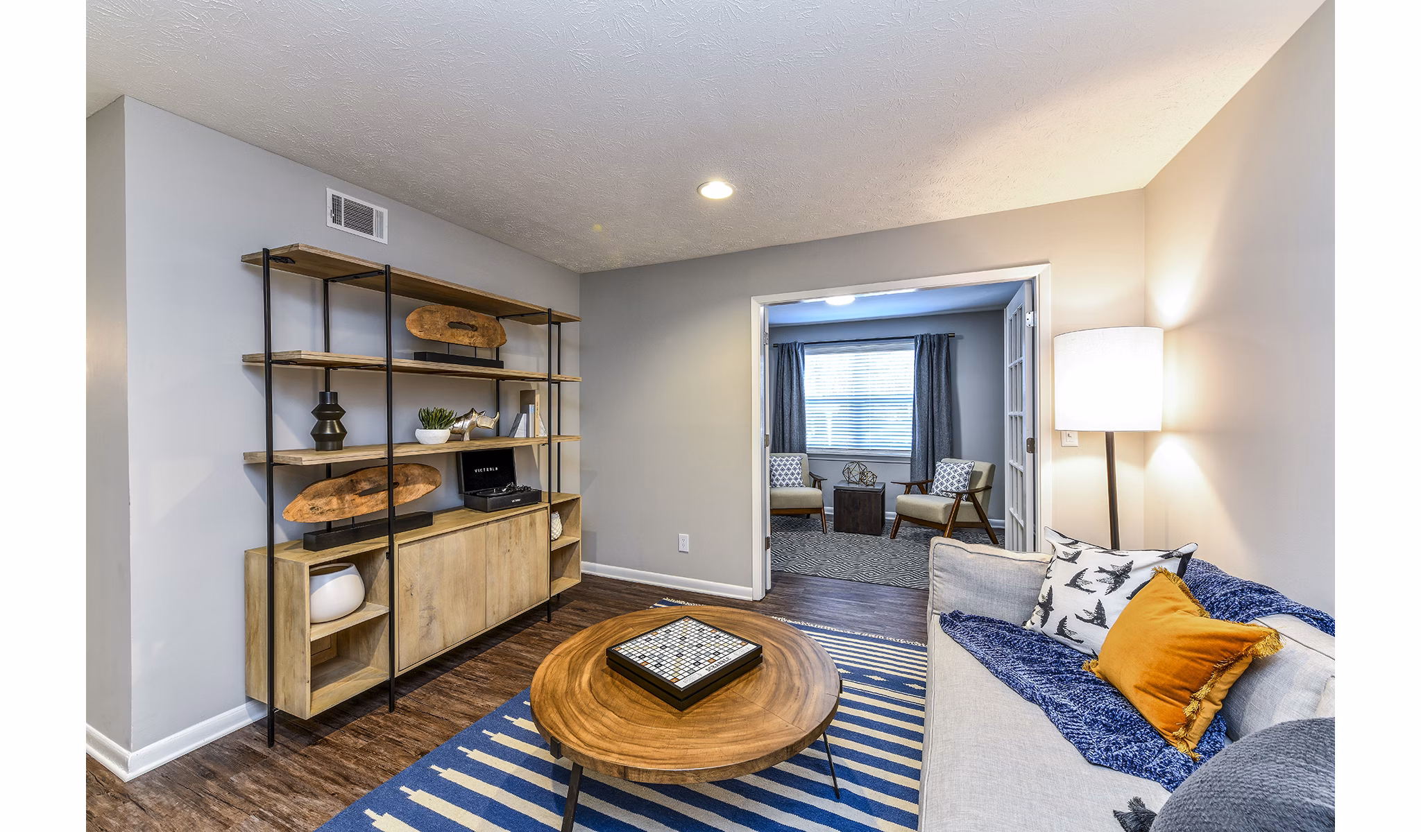 Contemporary living room with cozy seating at Avana Woods Apartments, featuring elegant dÃ©cor and natural light