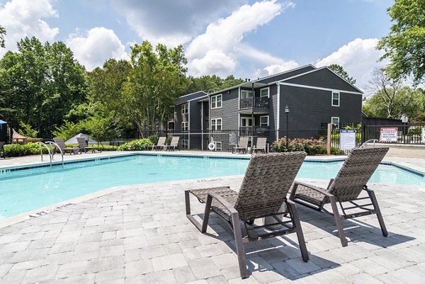 Relaxing pool area at Avana Woods Apartments with surrounding greenery, perfect for sunny days and leisure activities