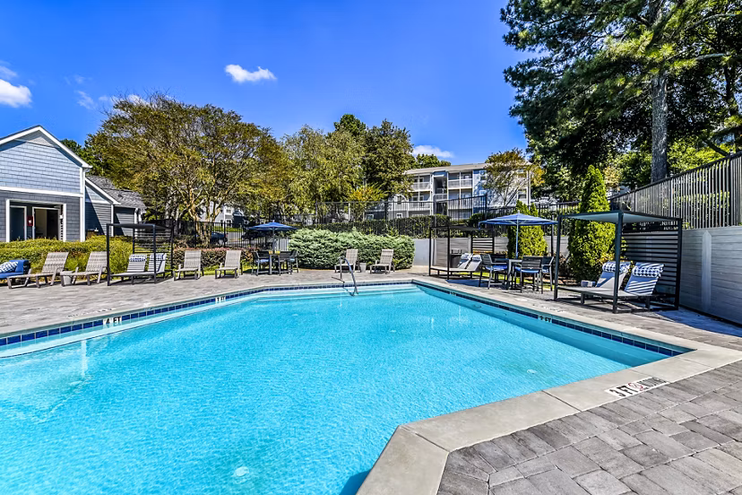 Relaxing poolside area with lounge chairs at Avana Woods Apartments, ideal for residents seeking a tranquil retreat