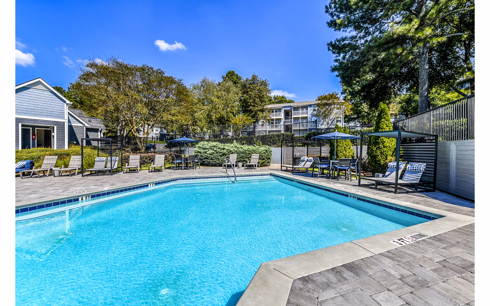Relaxing poolside area with lounge chairs at Avana Woods Apartments, ideal for residents seeking a tranquil retreat